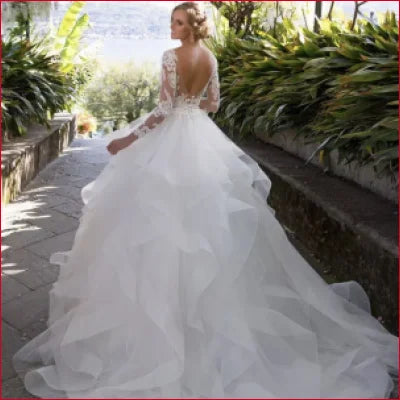 Elegant white wedding dress with tulle lace sleeves and ruffled backless skirt