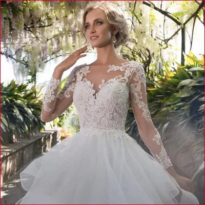 Elegant white wedding dress with tulle lace sleeves, backless design, and full skirt