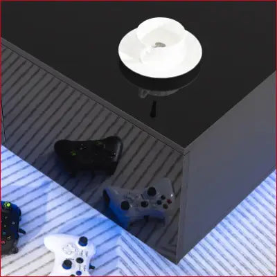 Black LED Coffee Table with 4 Drawers Modern Center and game controllers in living room