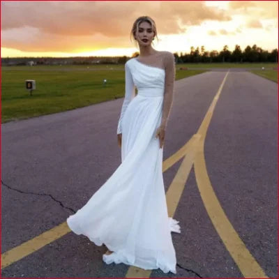 White one-shoulder wedding gown with flowing chiffon long sleeves and a high slit