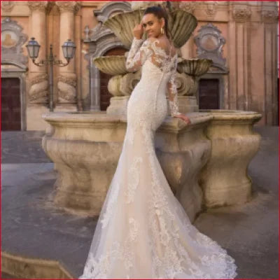 Elegant long-sleeved lace wedding gown with a long detachable train in white and ivory