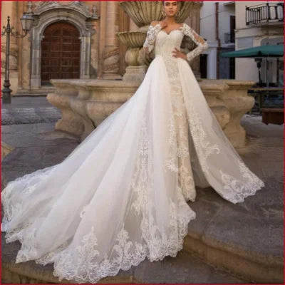 Ornate white wedding gown showcasing long lace sleeves and a long detachable train