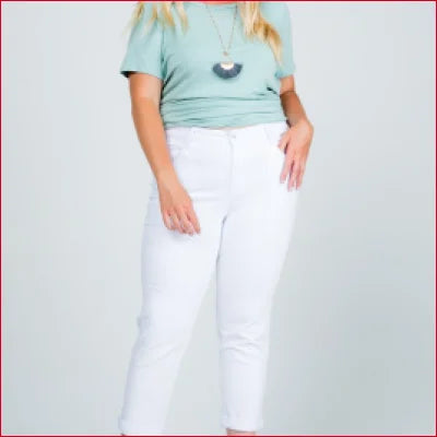 Woman in light blue t-shirt and white pants showcasing Mid Rise Boyfriend Jeans