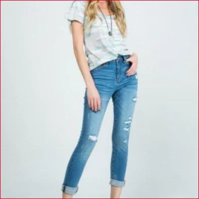 Pair of stretchy denim jeans with distressed details and rolled cuffs for trendy style