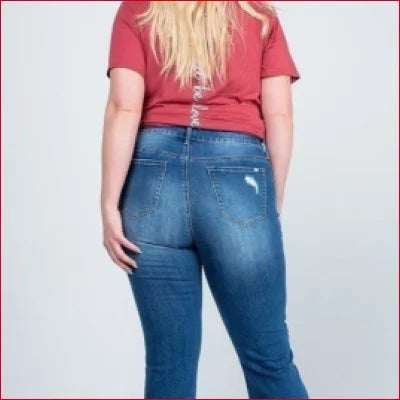 Woman in blue jeans and red t-shirt showcasing Vintage Kick Flare Jeans with ankle length distressed hem