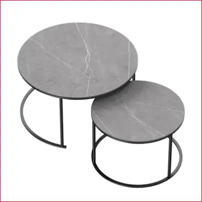 Two modern nesting round grey marble top tables with black metal legs for home decor