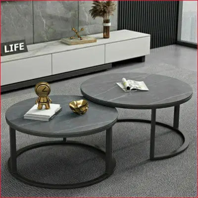 Two modern nesting round grey marble top coffee tables with metal legs and sintered stone