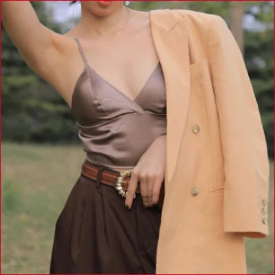 Woman in a peach coat showcases a Luxurious Mulberry Silk Bra in White, Black, or Grey