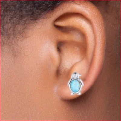 Turquoise gemstone earring in silver setting worn on earlobe for stylish comfort