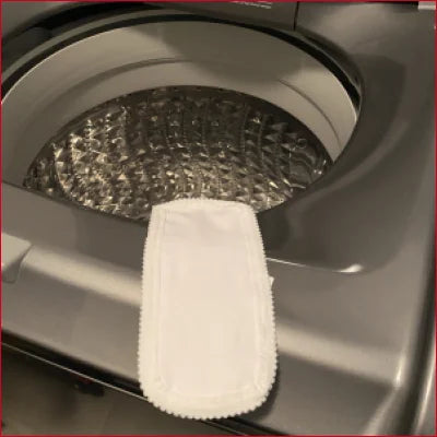 White microfiber cleaning pad in washing machine drum for padded leggings care