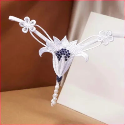 Delicate white lace bookmark with floral designs and pearl accents for intimate faux pearl lingerie