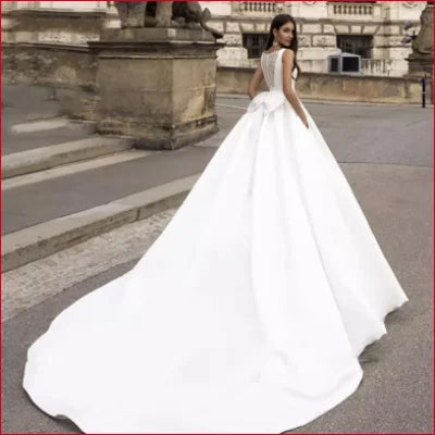 Elegant sleeveless satin bridal gown with a voluminous skirt and long train