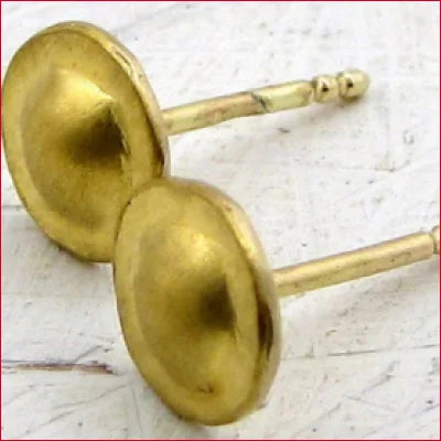 Gold stud earrings with concave faces inspired by ancient jewelry traditions