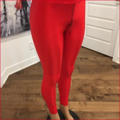 Bright red lycra crotch zipper leggings on a person standing on a wooden floor