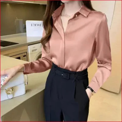 Pale pink button-up blouse with high-waisted navy trousers, showcasing blue satin silk style