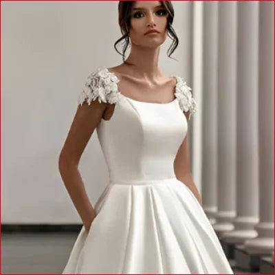 Elegant white wedding dress with floral cap sleeves and full skirt, perfect bridal gown