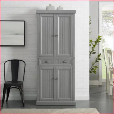 Gray pantry cabinet in Seaside Coastal Wood/Metal design, featuring distressed gray finish