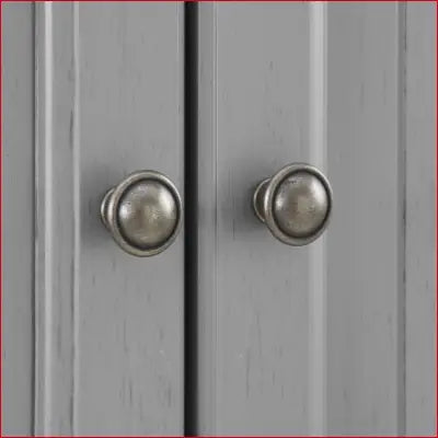 Gray cabinet doors with round metal knobs on Seaside Coastal Wood pantry in distressed gray