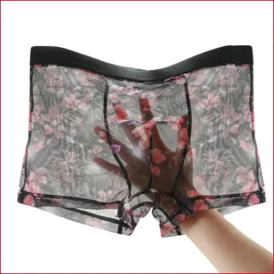 Sheer floral patterned boxer shorts lingerie with black waistband held in hand