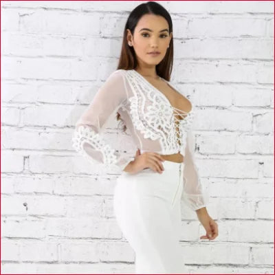 Woman in a sheer white crop top with long sleeves for a sexy, stylish look