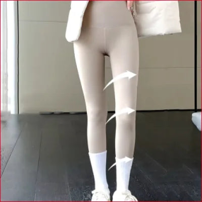 Beige ripped thermal leggings womans paired with white socks and sneakers for a stylish look