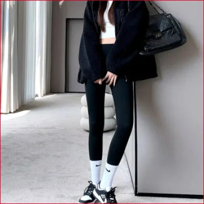 Person in sexy thermal leggings, all-black outfit with white socks and sneakers