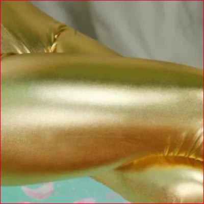 Gold metallic balloon reflecting light next to Shiny Disco Pants Women’s for a vibrant look