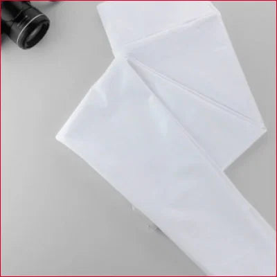 White folded cloth napkin with crisp edges beside Shiny Disco Pants Women’s in vibrant colors