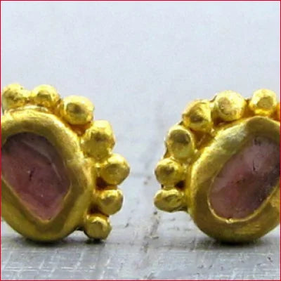 Beautiful stud earrings featuring gold with pink gemstones and decorative beads