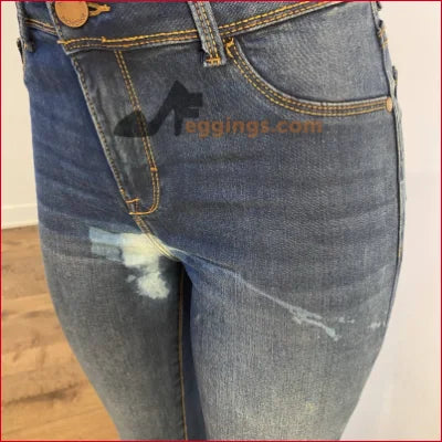 Distressed blue jeans with faded areas and logo, perfect for a unique look in stained women’s pencil style