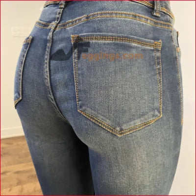 Pair of blue denim jeans with back pocket, featuring a stained women’s pencil design