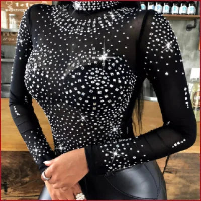 Studded black long sleeves bodysuit with rhinestones paired with leather leggings