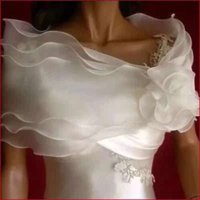 Flowing white wedding dress with tulle bolero bridal shoulder accessory and ruffled sleeves