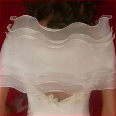 Flowing white tulle bolero bridal shoulder accessory over wedding dress bodice