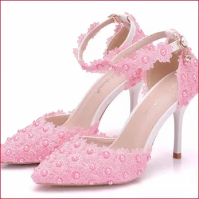 Pink high-heeled bridal shoes with floral appliqués, perfect for a wedding dress