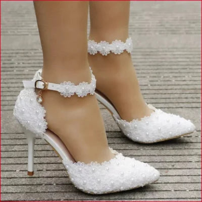 Elegant white bridal shoes with lace straps and floral embellishments for wedding dress