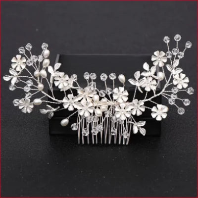 Ornate bridal comb hairpiece with white blossoms and crystal accents for gown purchase