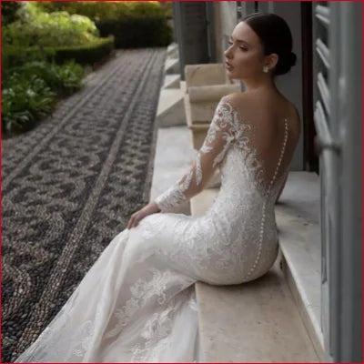 Elegant white lace mermaid styled wedding dress with long sleeves and open back