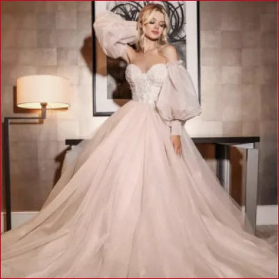 Elegant off-white wedding gown with detachable puffy sleeves and a voluminous skirt