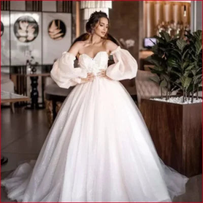 Elegant white wedding gown with detachable puffy sleeves and voluminous skirt