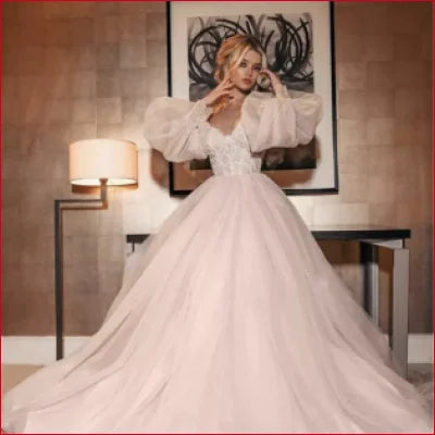 Voluminous white wedding gown with detachable puffy sleeves and full tulle skirt