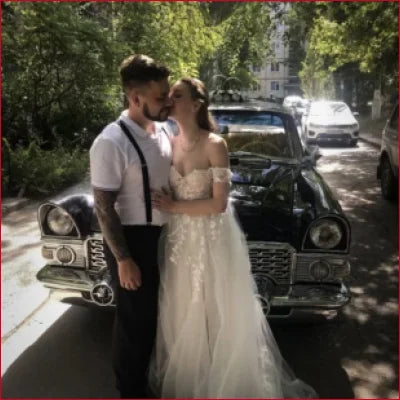 Vintage black car with chrome accents beside Boho A Line Bridal Gown with high slit